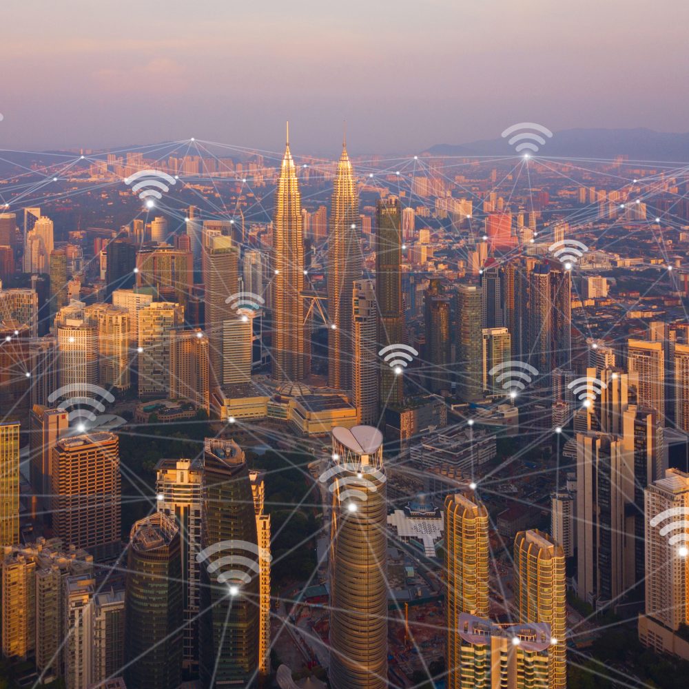 Digital network connection lines and wifi icons with Kuala Lumpur Downtown, Malaysia. Financial district in smart city in technology concept. Skyscraper and high-rise buildings at sunset